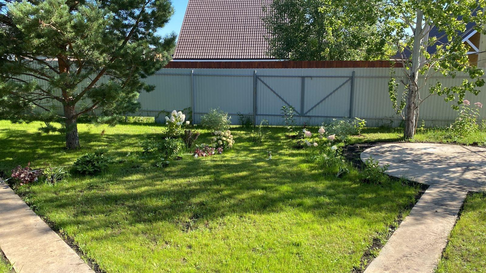 A Quiet Garden on 700 m², Shmidtovo — The lawn with the round patio at its end